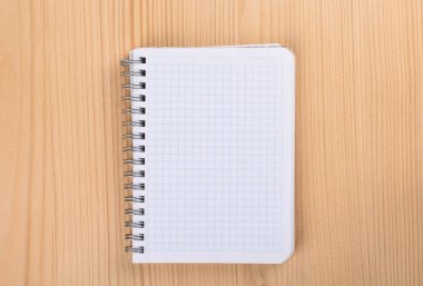 Ahşap masa üstü görünümünde kare kağıt defter.