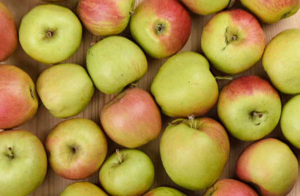 Pommes mûres sur un fond en bois. Beaucoup de pommes comme toile de fond . — Photo