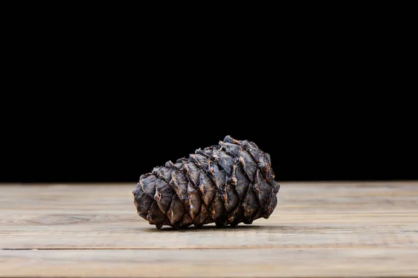 Taiga cedar cone on a wooden table. Stock Picture