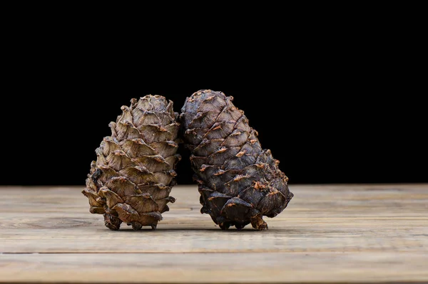 Dos conos de cedro en una mesa de madera. Resina de cedro en un bache . — Foto de Stock