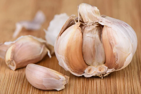 Head of garlic and several cloves of unpeeled garlic.