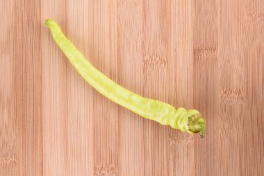 Ahşap bir arka plan üzerinde acı yeşil biber. Yatay.