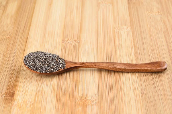 Wooden spoon with chia seeds on wooden background. — Stock Photo, Image