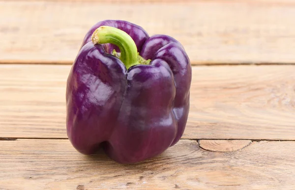 Fresh purple bell pepper on a wooden table. — Stock Photo, Image