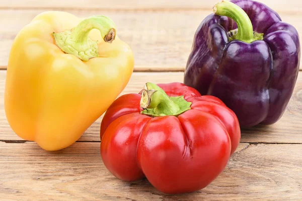 Colorful sweet pepper bells on a wooden table. — Stock Photo, Image