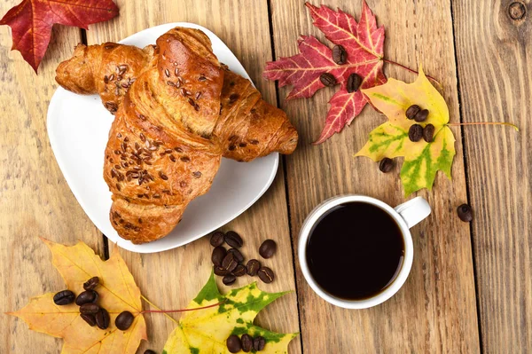 Herbstfrühstück mit französischen Croissants und einer Tasse Kaffee. Ansicht von oben. — Stockfoto