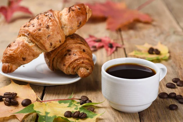 Herbstfrühstück mit französischem Croissant und einer Tasse Kaffee. — Stockfoto