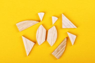 Sarı arkaplan üzerinde dokuz parça tangram bulmaca oyunu. 