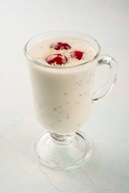 Hindistan cevizi gevreği ve kirazlı yoğurt pudingi. Gücü geri getirmek ve kilo vermek için sağlıklı beslenme. Chia ve yoğurt pudingi cam kasede..