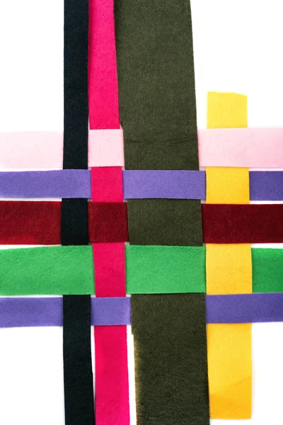 Threaded multi-colored strips of felt fabric horizontally on a white background.