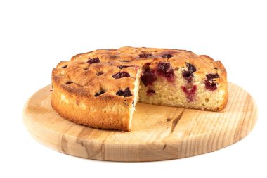 Beyaz arka planda kesme tahtasında üçgen şeklinde kesilmiş vişneli turta. Ev yapımı vişneli turta.