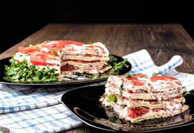 Siyah bir tabakta kabak gözlemesi, krema ve domatesten yapılmış vejetaryen turtası. Yumuşak odak.