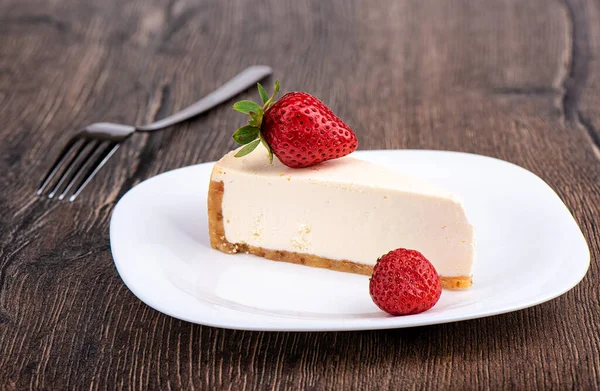 Fatia de cheesecake com morangos em um prato branco. — Fotografia de Stock