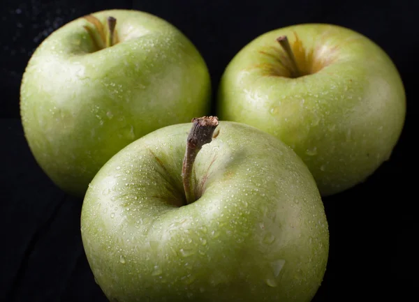 Green apple on black background