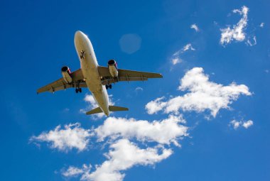 Arka plan mavi gökyüzü ve beyaz bulutlar uçakta.