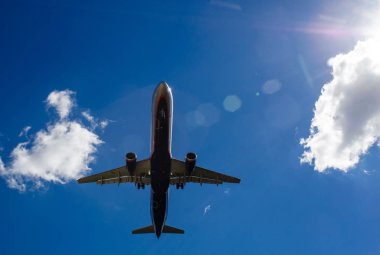 Arka plan mavi gökyüzü ve beyaz bulutlar uçakta.