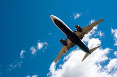 Arka plan mavi gökyüzü ve beyaz bulutlar uçakta.