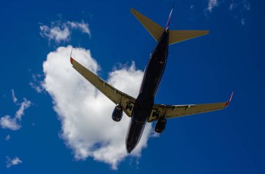 Arka plan mavi gökyüzü ve beyaz bulutlar uçakta.