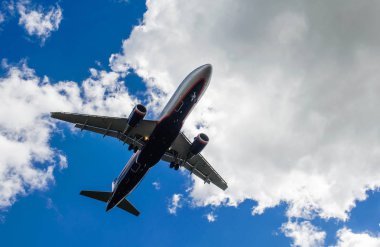 Arka plan mavi gökyüzü ve beyaz bulutlar uçakta.