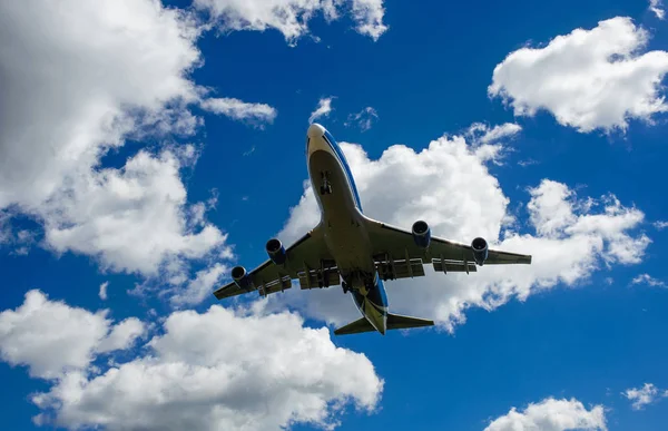 Arka plan mavi gökyüzü ve beyaz bulutlar uçakta.