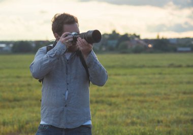 Genç bir beyaz adam alan ve fotoğraf çekimi üzerinde yürüyen bir kamera ile.