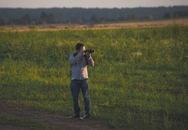Genç bir beyaz adam alan ve fotoğraf çekimi üzerinde yürüyen bir kamera ile.