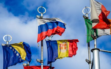 Mavi gökyüzüne karşı bayrak direkleri üzerinde Avrupa ülkelerinin bayrakları.