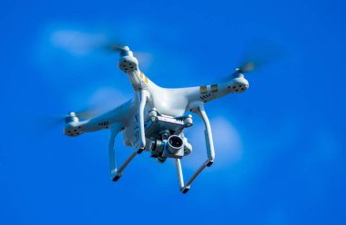 Quadcopter mavi gökyüzü arka plan üzerinde uçan.