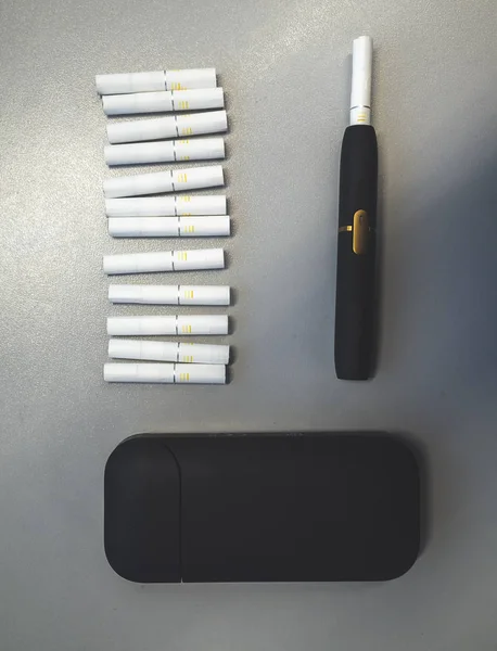 Tobacco heating system and a pack of tobacco sticks on a gray background