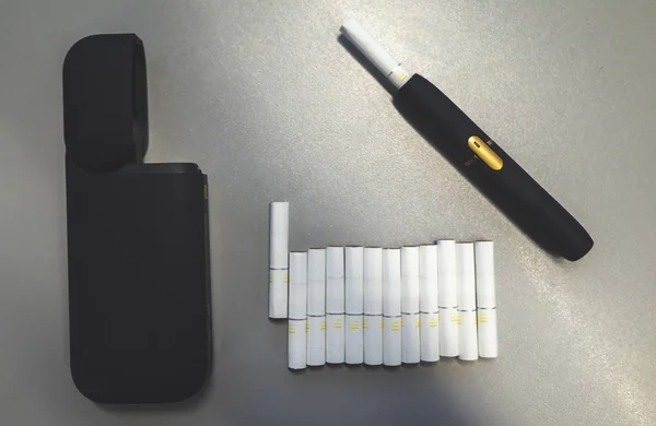 烟草加热系统和一包灰色背景上的烟棍 — 图库照片