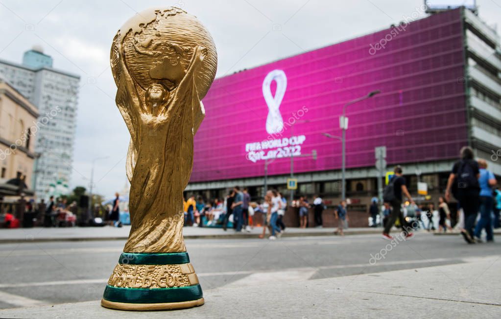 4 September 2019, Moscow, Russia. Copy of world cup trophy on background logo of the FIFA world Cup 2022, which will be held in Qatar, on a giant screen in the city center.
