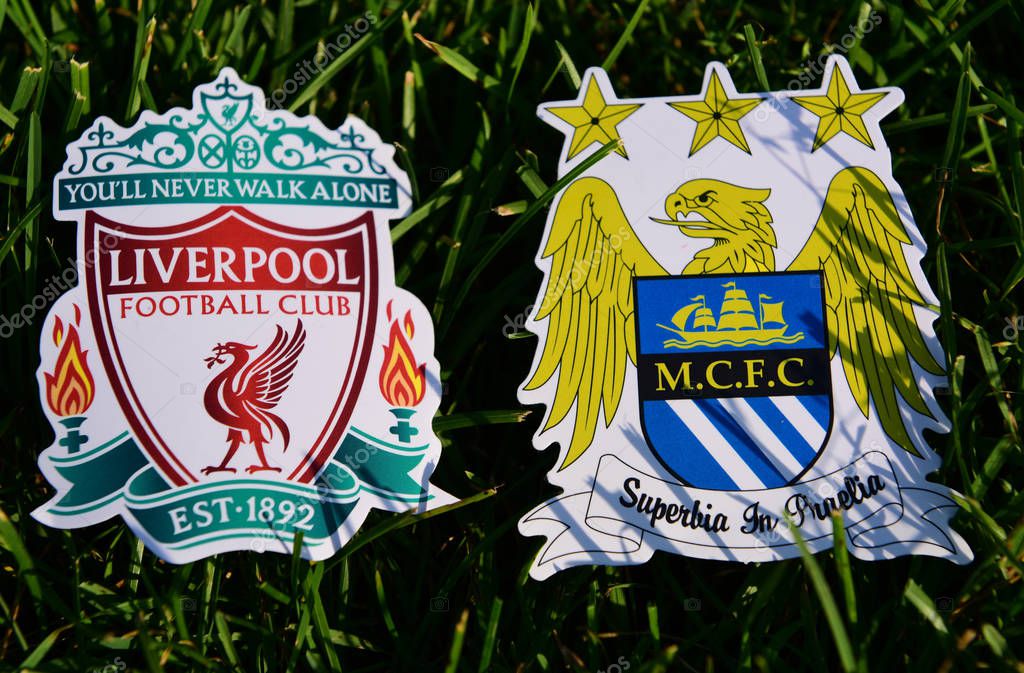 September 6, 2019 London, UK. Emblems of English football clubs Manchester City and Liverpool on the green lawn grass.