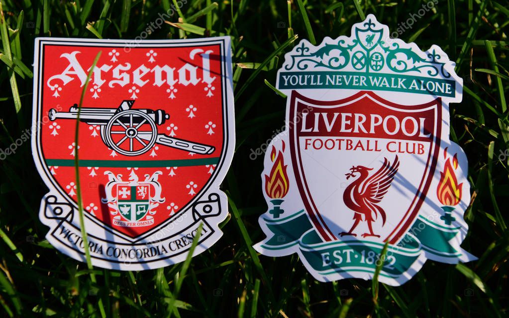September 6, 2019 London, UK. Emblems of English football clubs rsenal F.C. London  and Liverpool on the green lawn grass.