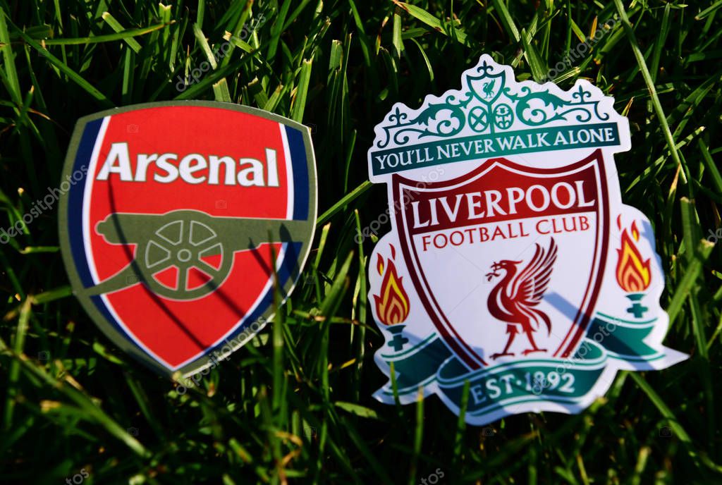 September 6, 2019 London, UK. Emblems of English football clubs rsenal F.C. London  and Liverpool on the green lawn grass.