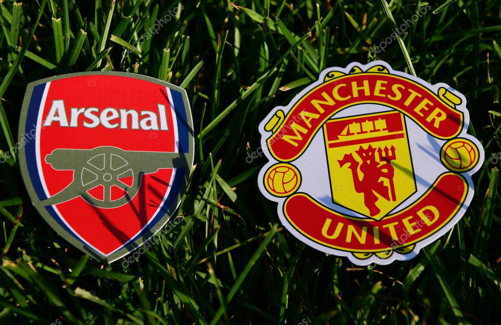 September 6, 2019 London, UK. Emblems of English football clubs rsenal F.C. London  and Manchester United on the green lawn grass.