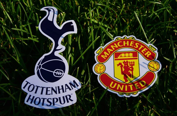 6 Eylül 2019 Londra, Uk. İngiliz futbol kulüpleri Tottenham Hotspur London ve Manchester United 'ın amblemleri yeşil çimlerin üzerinde.