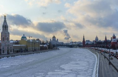 Kremlin seti üzerinde arabalar ve açık bir kış gününde donmuş Moskova nehri..