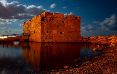 Paphos şehrindeki Akdeniz kıyılarındaki ortaçağ şatosu dolunay ışığında Kıbrıs adasında..