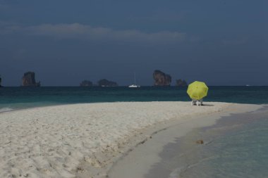 Sahilde şemsiyesi olan dikiz aynalı adam.