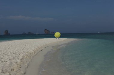 Sahilde şemsiyesi olan dikiz aynalı adam.