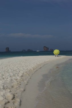 Sahilde şemsiyesi olan dikiz aynalı adam.