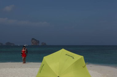 Sahilde şemsiyesi olan dikiz aynalı adam.