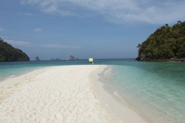 Sahilde şemsiyesi olan dikiz aynalı adam.