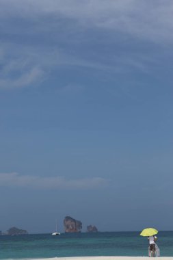 Sahilde şemsiyesi olan dikiz aynalı adam.