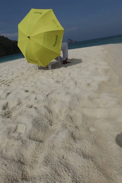 Sahilde şemsiyesi olan dikiz aynalı adam.