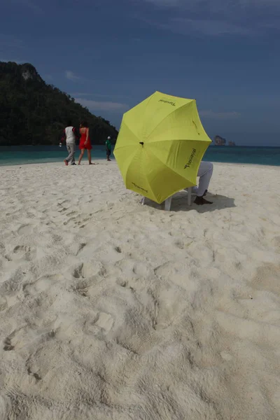 Sahilde şemsiyesi olan dikiz aynalı adam.