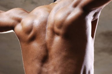 Spor salonunda kaslı bir erkek var.