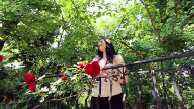 Genç ve güzel kız gül bahçesinde.