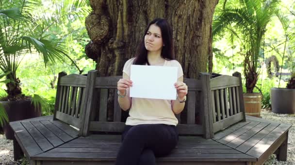 Menina Uma Blusa Bege Contra Uma Árvore Grossa Mostra Inscrição — Vídeo de Stock