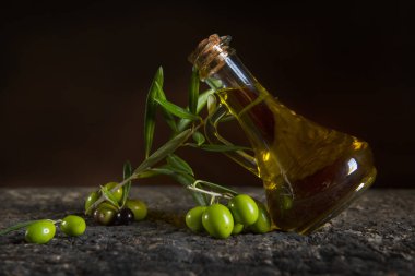 Zeytinyağı ve taze zeytin eski masada.